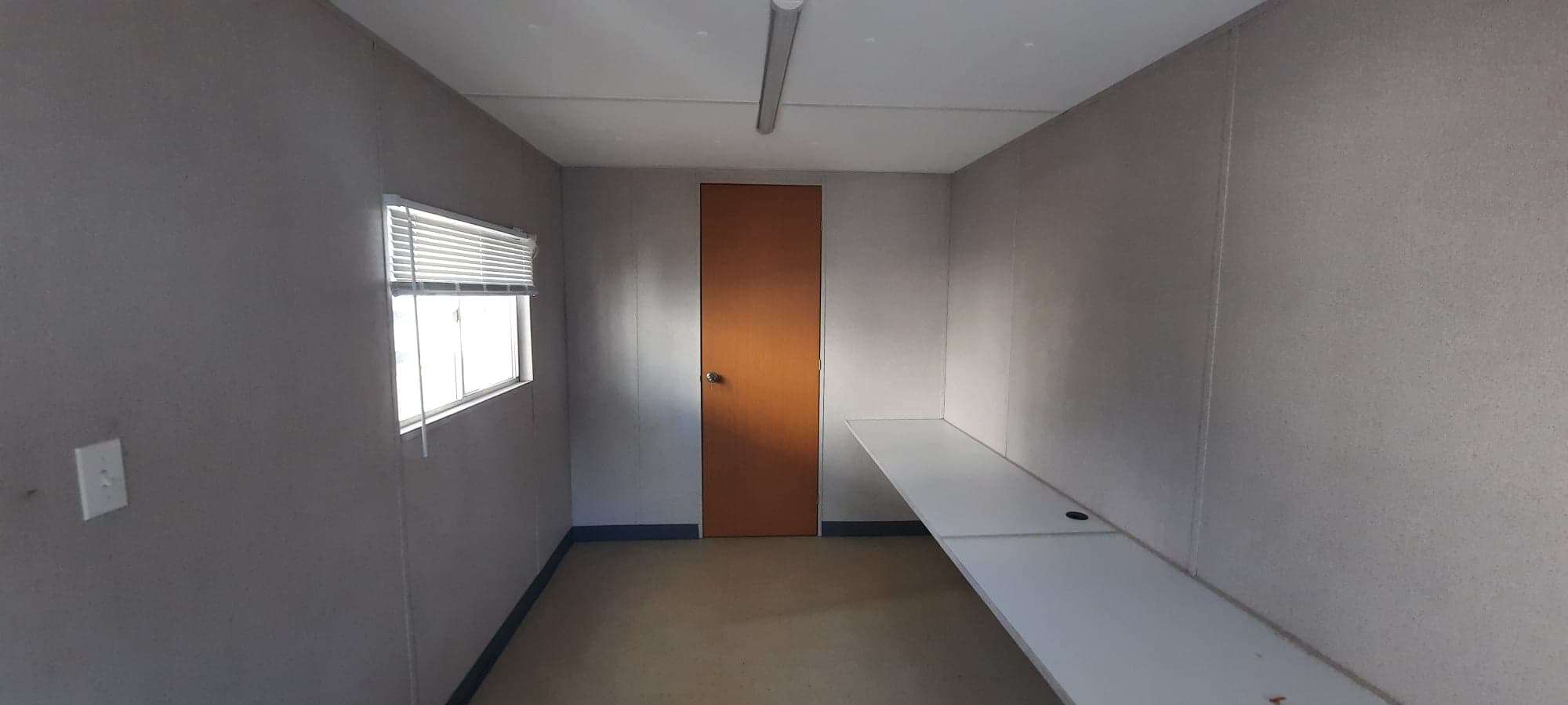 Oficina móvil con acabados interiores en panel de vinil y acabado exterior en lamina pintro acanalada. 